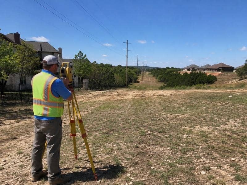 Boundary Survey in Austin TX showing a surveyor measuring a residential lot with an easement through the buildable area.